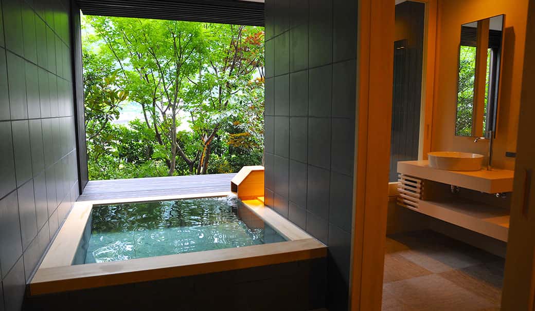 A quiet private outdoor onsen surrounded by a bamboo garden